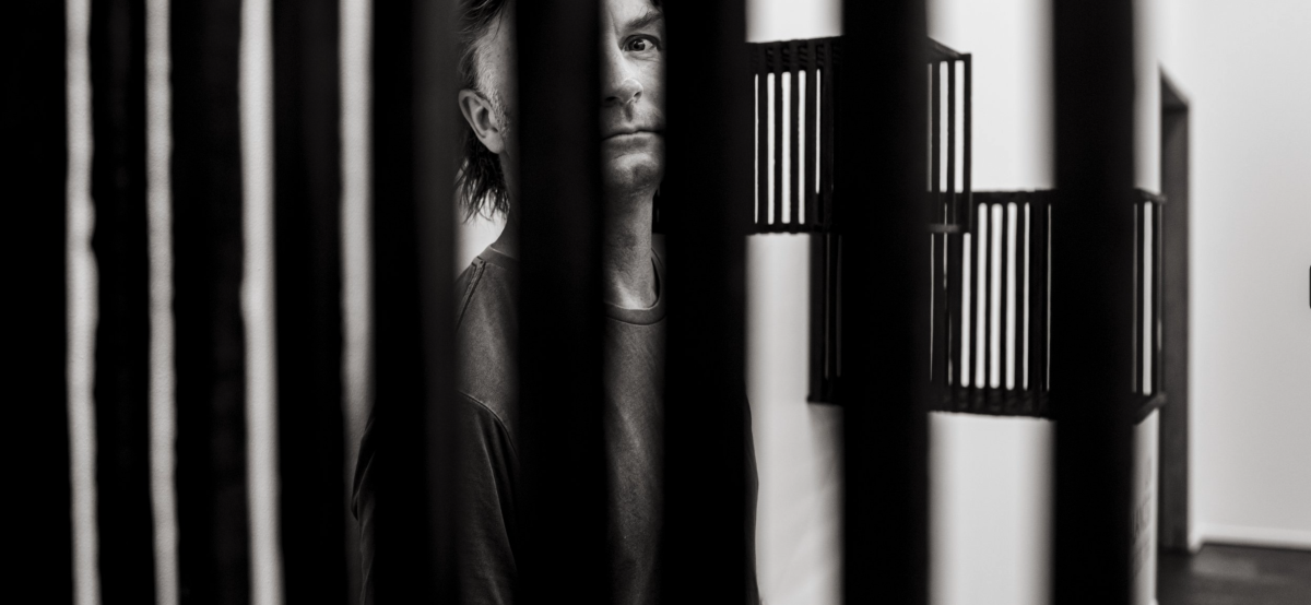 Artist Chick Butcher peers through slats